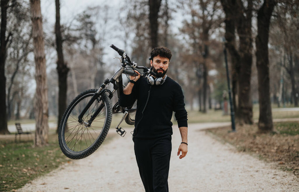 Egy biciklis üzletember magabiztosan sétál a nyugodt parkban, a professzionalizmus és az aktív városi életmód keverékét testesítve meg.. - Fotó, kép
