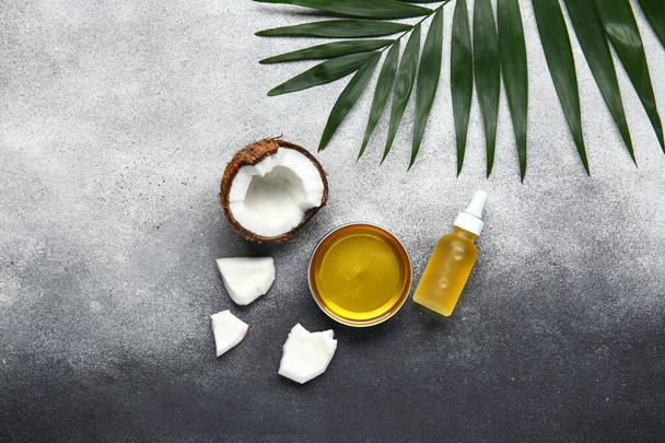 Butelka i miska oleju kokosowego z liściem palmy na gradientowym tle - Zdjęcie, obraz