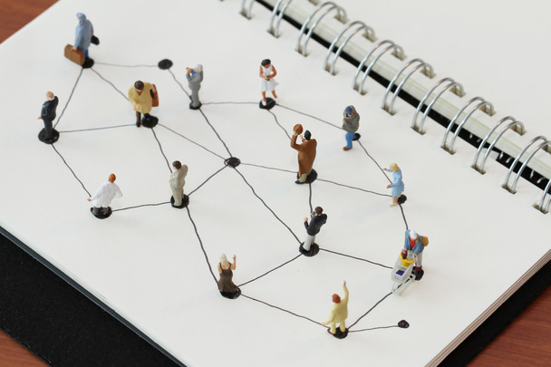 Nahaufnahme von Miniaturmenschen mit sozialem Netzwerkdiagramm auf offenen - Foto, Bild
