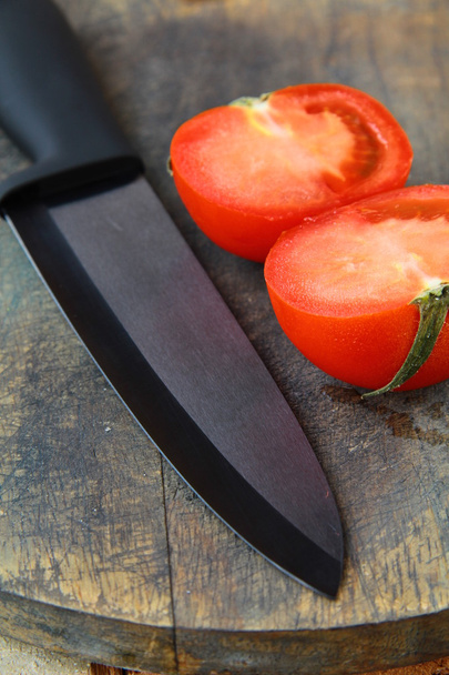 nóż ceramiczny i pomidorów na drewnianym stole - Zdjęcie, obraz