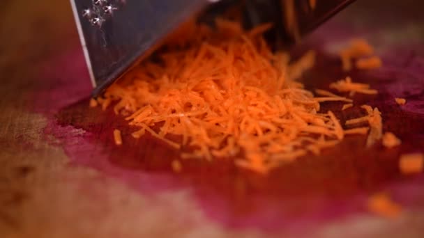 Video s jemně nastrouhanou mrkví připravovanou na řezacím prkně. Ideální pro vaření videa, zdravé recepty a scény přípravy jídla. - Záběry, video