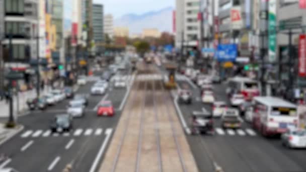 Time Lapse elmosódott videó egy nyüzsgő utcán számos autó, busz, és a gyalogosok. Az utca széles, és villamosvonalak futnak végig a központon.. - Felvétel, videó