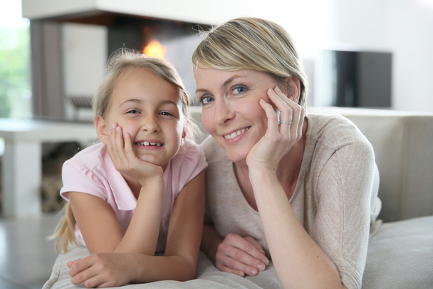 Mother and daughter laying on couch - Foto, imagen