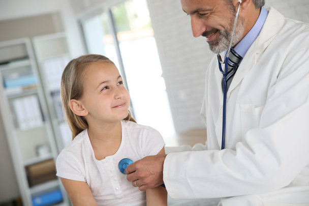 Doctor examining girl with stethoscope - Фото, зображення
