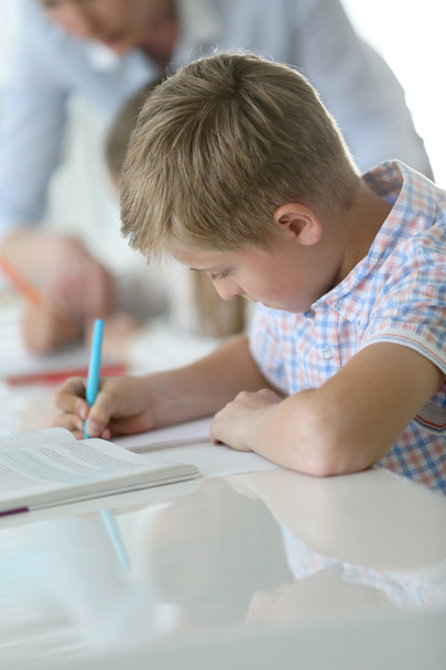 Schoolboy writing on notebook - Φωτογραφία, εικόνα
