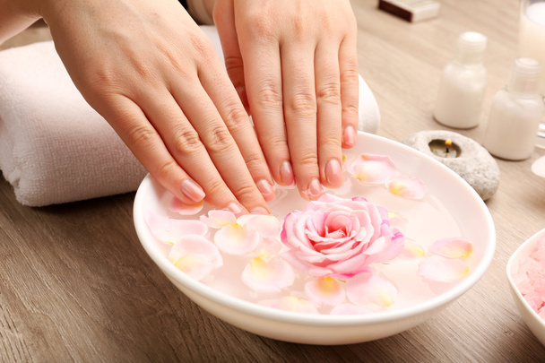 Female hands and bowl of spa water with flowers, closeup - Fotoğraf, Görsel
