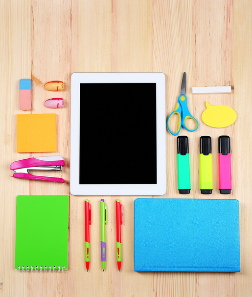 Digital tablet with stationery on wooden background - Foto, afbeelding