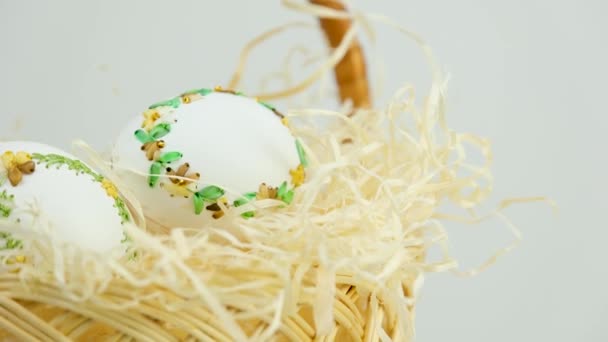Draadborduurwerk op eieren. Handgemaakte kunst. Pasen in een rieten rieten mand zijn er witte eieren met een mooie decoratie van linten om thuis te borduren - Video