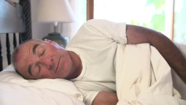 Senior man sleeping and then waking up - Filmati, video