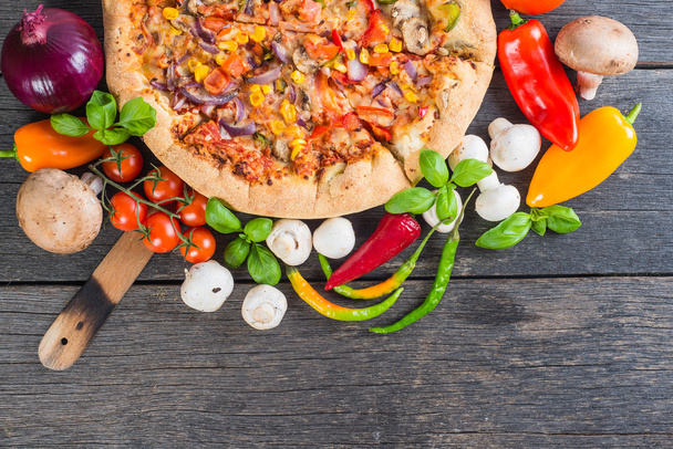 Pizza vegetariana caseira de cima na mesa de madeira
 - Foto, Imagem
