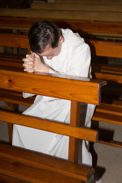 Αγόρι χαμηλώματος της ανάρτησης και να προσεύχονται στην εκκλησία - Φωτογραφία, εικόνα