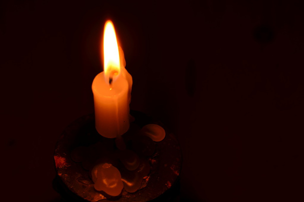 Candle in candlestick on dark background - Фото, изображение