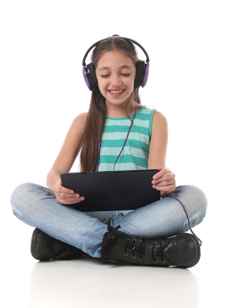 Beautiful pre-teen girl with a tablet computer. - Foto, immagini