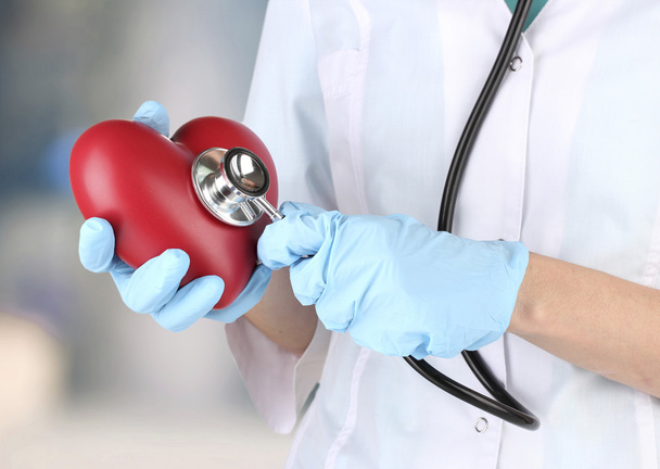Stethoscope with heart in doctor hands, close up - Photo, Image