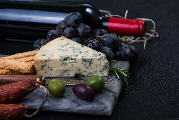 Marble board with cheese selection, wine and grapes - Photo, Image