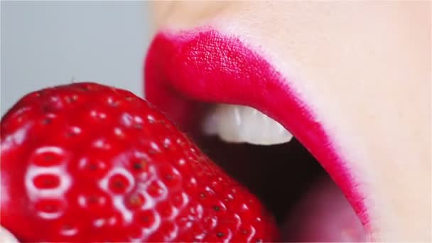 Αισθησιακό κόκκινο τα χείλη δάγκωμα φράουλα - Πλάνα, βίντεο