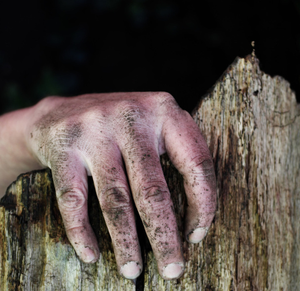 Βρώμικο χέρι ενός ανθρώπου στην άκρη του ένα σπασμένο φράχτη - Φωτογραφία, εικόνα