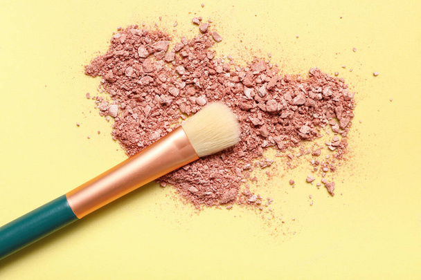 Makeup brush and highlighter on yellow background - Photo, Image