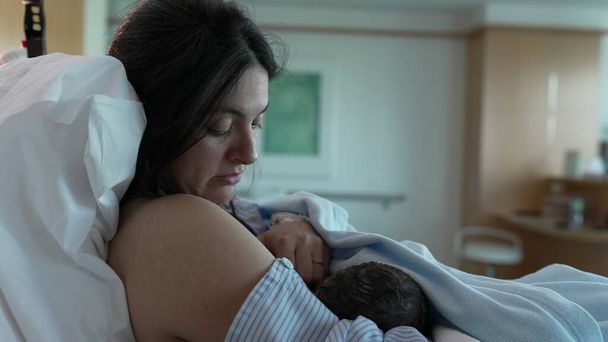 Intimate First Breastfeeding Session - New Mother Feeds Newborn at Hospital After Birth, Emphasizing Maternal Bonding and Care in Clinical Setting - Photo, Image