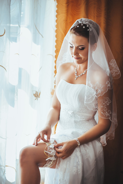 Bride getting ready. beautiful bride in white wedding dress with hairstyle and bright makeup. Happy sexy girl waiting for groom. Romantic lady in bridal dress have final preparation for wedding - Photo, image