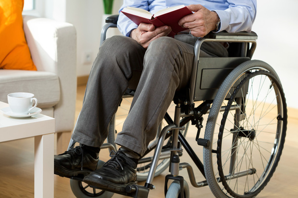 Man on wheelchair reading a book - 写真・画像