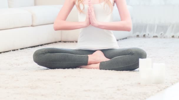 Young woman sitting and meditating doing yoga - Felvétel, videó