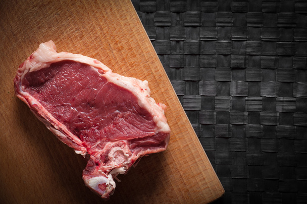 Piece of meat on chopping board - Foto, afbeelding