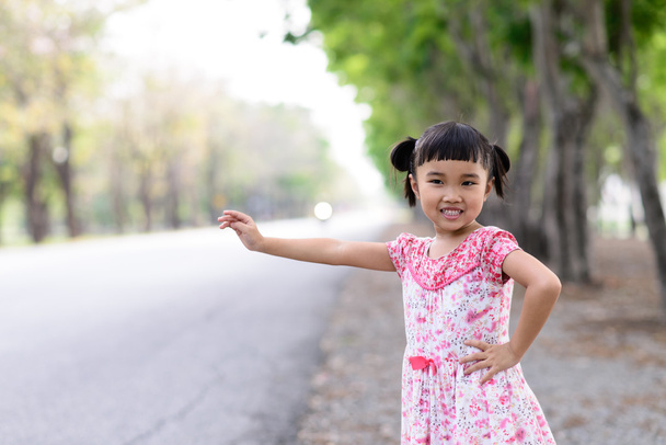 Kind doen een wuivende oproep op de weg - Foto, afbeelding
