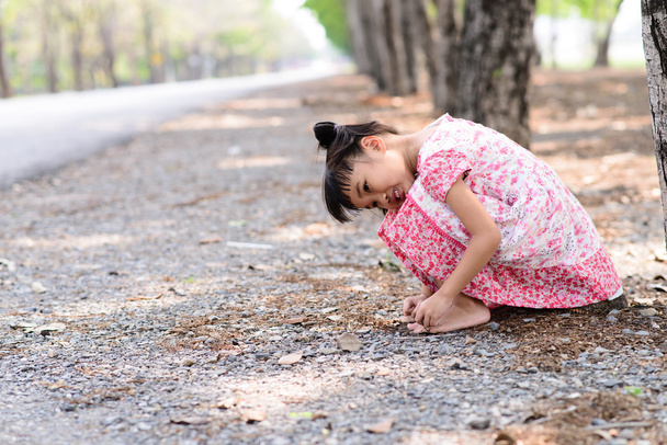 Criança com vestido vermelho situado no chão
 - Foto, Imagem