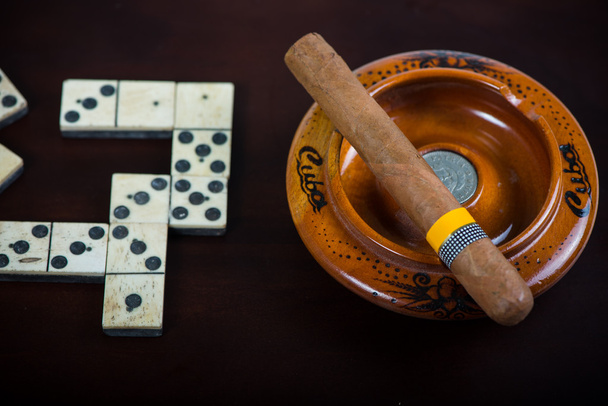 Kubánský doutník v popelníku a domino - Fotografie, Obrázek