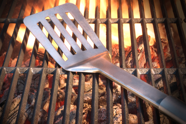 A forró lángoló Grill közelről a spatula - Fotó, kép