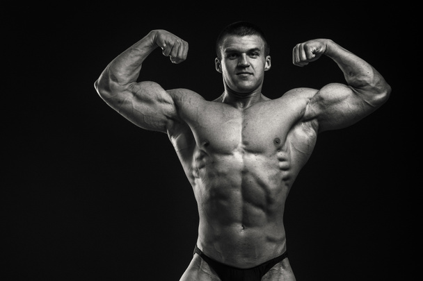 Bodybuilder shows his muscles - 写真・画像