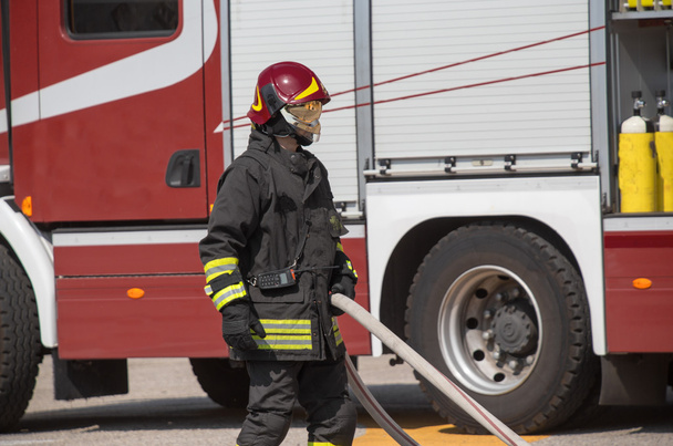 ホースで消防士が火災と、firetruc を出して - 写真・画像