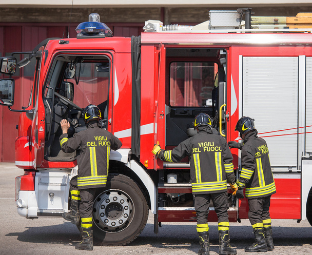 Ιταλική πυροσβέστες ανεβείτε στο firetrucks σε καταστάσεις έκτακτης ανάγκης - Φωτογραφία, εικόνα