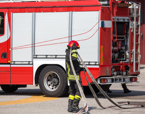 пожарные со шлангом, чтобы потушить пожары и пожарные
 - Фото, изображение