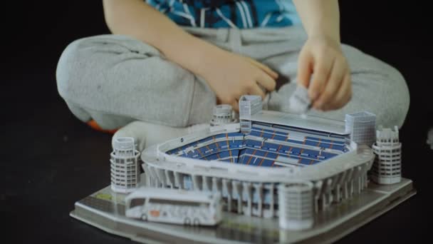 dítě sbírá hračku sportovní stadion blízký záběr jezdce černé pozadí - Záběry, video