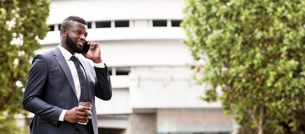 Πάντα σε επαφή. Αφρικανός Αμερικανός επιχειρηματίας μιλάει στο κινητό τηλέφωνο κατά τη διάρκεια του καφέ διάλειμμα στην πόλη. Ελεύθερος χώρος - Φωτογραφία, εικόνα