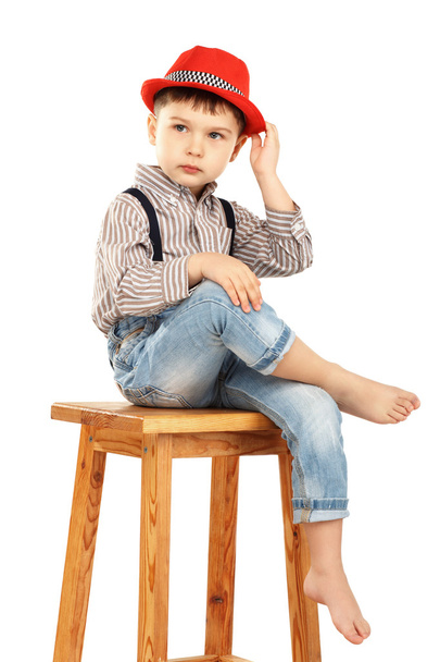 Portrét legrační malý chlapec seděl na vysoké stoličce v červené  - Fotografie, Obrázek