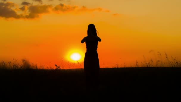 Silhouette d'une fille pratiquant le yoga au coucher du soleil
 - Séquence, vidéo