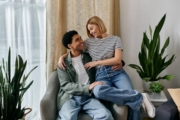 A young multicultural couple shares a loving moment in their modern apartment - 写真・画像