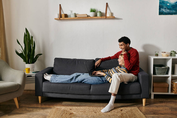 A happy, multicultural couple enjoys quality time together in their modern apartment. - Foto, Imagen