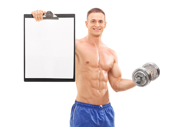 Handsome athlete holding barbell and a clipboard - Фото, зображення