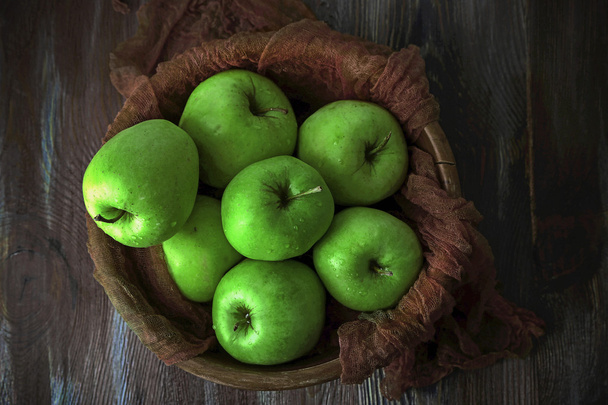 Green apples in bowl with fabric on wooden table, top view - Fotografie, Obrázek