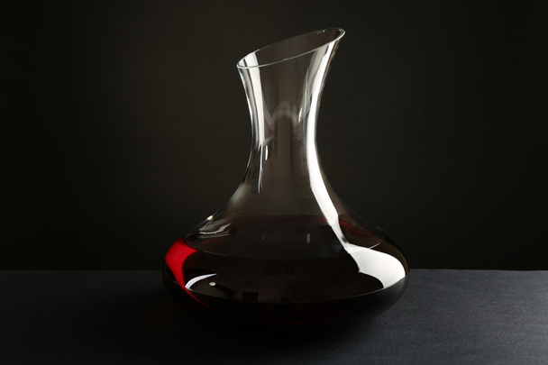 Glass carafe of wine on dark background - 写真・画像
