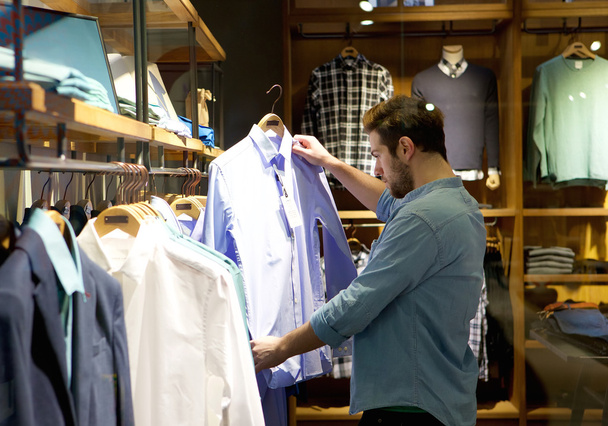 Jeune homme magasinant pour des vêtements au magasin
 - Photo, image