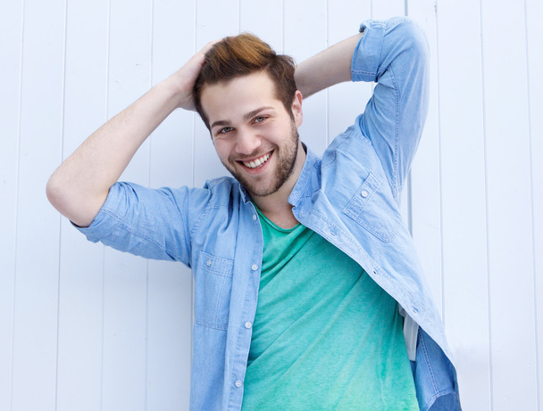 Cool fashionable guy smiling with hands in hair - Photo, Image