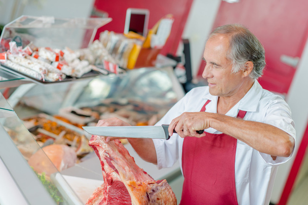 Experienced butcher in his shop - Fotoğraf, Görsel