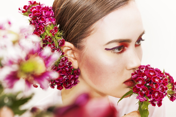 Pretty girl beauty portrait smelling flowers and looking aside - 写真・画像