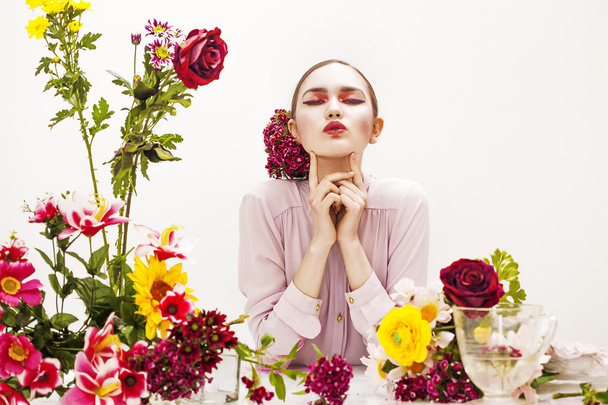 Pretty woman portrait sitting at the table with flowers - Zdjęcie, obraz