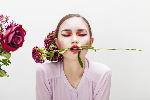 Woman beauty portrait biting flower branch with closed eyes - Zdjęcie, obraz